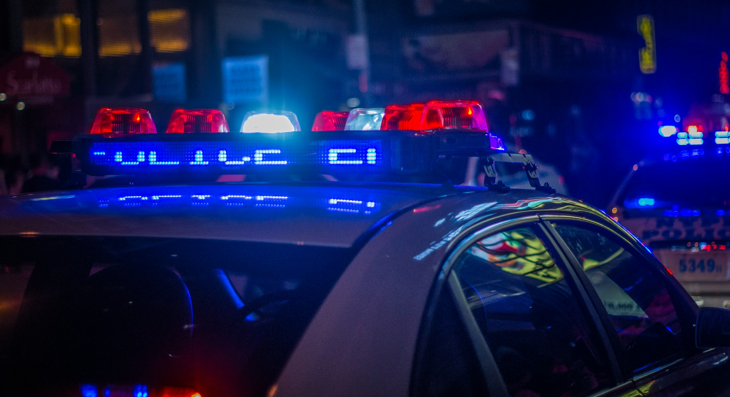 Auto delle forze dell'ordine con lampeggianti blu e rossi accesi di notte